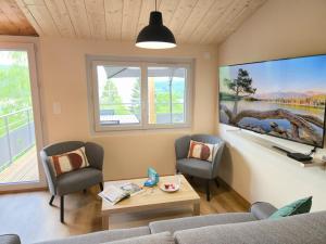 a living room with a couch and two chairs at Les Reflets Bleus in Maisod