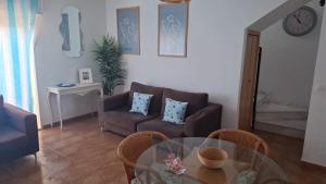 a living room with a glass table and a couch at Ático Playa in Cartagena