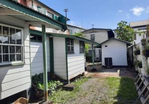 an old house with a balcony and a yard at Tiny house in Paramaribo