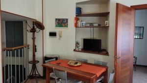 a dining room with a table and a television at Rose Apartment in Crotone