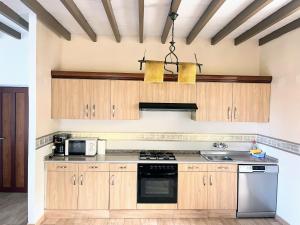 a kitchen with wooden cabinets and a stove top oven at Casa Rua in Lira +17 photos