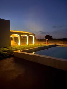a person walking in front of a house with a swimming pool at Casas do Seixo - Monsaraz in Cabeça de Carneiro +58 photos
