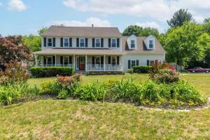 a house with a yard with flowers at Lrge 5 BR 9 Beds Near DC-Pool, Hot Tub, Gym, Game Rm, Fire Pit in Bowie