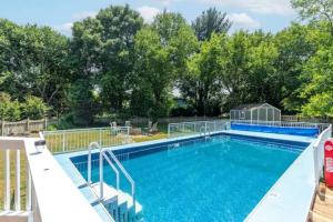 a large swimming pool with blue water at Lrge 5 BR 9 Beds Near DC-Pool, Hot Tub, Gym, Game Rm, Fire Pit in Bowie
