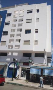 a man standing in front of a white building at Resicence jaouharat zarkaa in M'diq