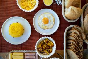 a table topped with plates of eggs and bread at Pousada Vila de Charme in Lençóis