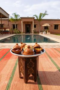 a tray of food on a table in front of a pool at Villa Dar Nata Marrakech in El Mers