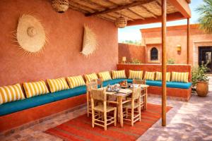 a patio with a blue couch and a table and chairs at Villa Dar Nata Marrakech in El Mers