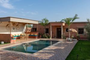 a house with a swimming pool in front of a house at Villa Dar Nata Marrakech in El Mers