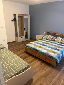 a bedroom with two beds and a mirror at Al Vicolo in Telve