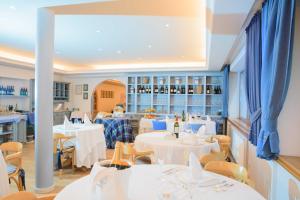 a dining room with white tables and chairs at Hotel La Villa in La Villa