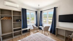a living room with a tv and some windows at 7 LAKES Aparthotel in Burolo