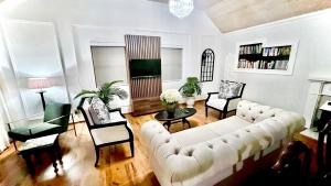 a living room with a white couch and chairs at Serenity Suite in Somerset West