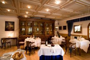 a restaurant with white tables and chairs and a ceiling at Hotel La Villa in La Villa +33 photos