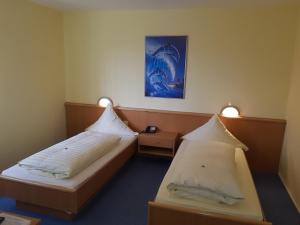a hotel room with two beds and two lights at Hotel Stadt Baunatal in Baunatal