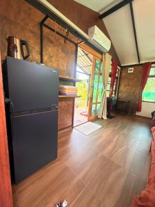a kitchen with a refrigerator and a wooden floor at Tee Bungalow in the jungle in Ao Nang 