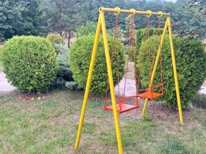 an empty swing set in a yard with bushes at Kulata Predel in Razlog