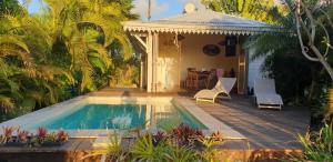 a house with a swimming pool and a porch at villas courbaril in Saint-Louis