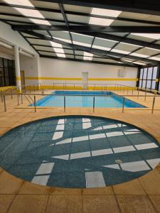 a large swimming pool in a building with ailed floor at Hotel Senhora do Espinheiro in Seia