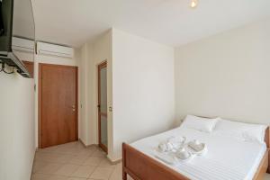 a bedroom with a white bed with white pillows at Hotel Boutique Vioalv in Sarandë
