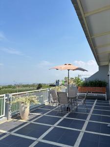 a patio with chairs and an umbrella on a balcony at Villa Ostara Kota Batu in Batu