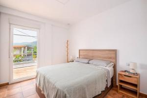 a white bedroom with a bed and a large window at Casa Rural El Bressol in Barraca de Aguas Vivas +55 photos