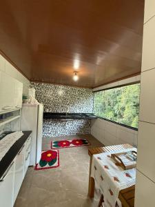 a small kitchen with a table and a refrigerator at Recanto Pin in Alfredo Chaves