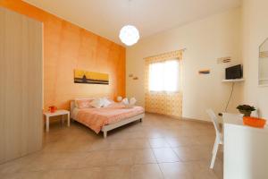 um quarto com uma cama, uma mesa e uma janela em B&B Bianco Sale Trapani em Rilievo