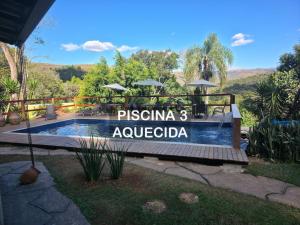a swimming pool with a sign that reads pisa aquidad at Pousada do Rodrigo in Macacos