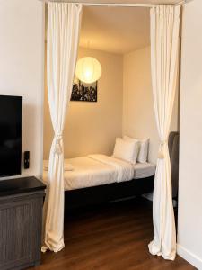 a bedroom with a bed with curtains and a tv at Luxury 3-Beds Apartment in Yorkville with the Best City View in Downtown Toronto in Toronto