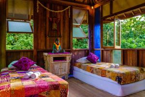 two beds in a room with windows at BoHo Bingin Beach Bali in Uluwatu
