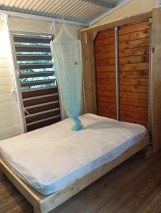 a bed with a net on top of it at cabane dans le jardin in Morne-à-lʼEau