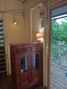 a wooden cabinet with a lamp on a porch at cabane dans le jardin in Morne-à-lʼEau