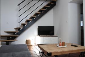 a living room with a couch and a tv and a table at Gîte de la Dheune in Essertenne