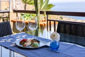 a plate of food on a table with two wine glasses at Little Paradise in Taormina