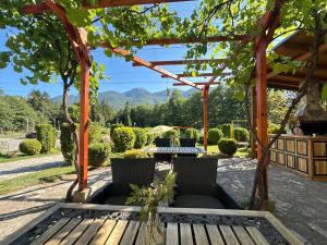 a pergola with a table and chairs in a garden at Kulata Predel in Razlog +19 photos