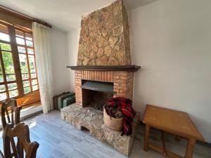 a living room with a stone fireplace and a table at Casa Lobo in Ucero +1 photo