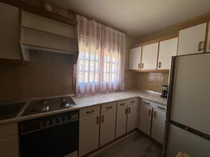 a kitchen with white cabinets and a sink and a refrigerator at Casa Lobo in Ucero