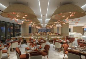 a restaurant with tables and chairs and large chandeliers at The Encore Hotel Nakuru in Nakuru