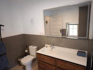 a bathroom with a sink and a toilet and a mirror at Casa Limón - Alpujarras in Órgiva