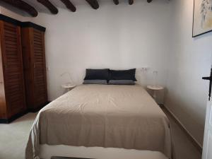 a white bedroom with a bed and two tables at Casa Limón - Alpujarras in Órgiva