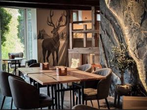 a dining room with a wooden table and chairs at Vanaga Ligzda in Baltezers