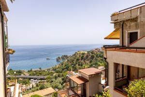 a view of the ocean from between buildings at Little Paradise in Taormina