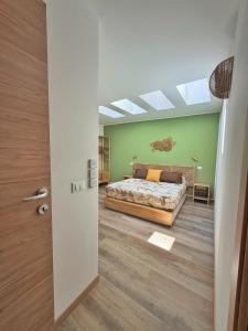 a bedroom with a bed and a green wall at Amelia Apartment in Maniago