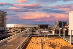 a balcony with chairs and a table and a view of the ocean at Lofts Orizon in Rimouski +69 photos
