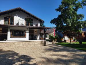 a house with a tree and a brick driveway at Casa Carolianne in Bran