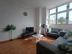 a living room with a couch and a tv at La Casita de Héctor in Arinaga