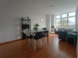 a living room with a table and chairs and a couch at La Casita de Héctor in Arinaga +12 photos