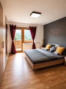 a bedroom with a large bed with red curtains at Ferienwohnung Biohof Untermar in Obervellach