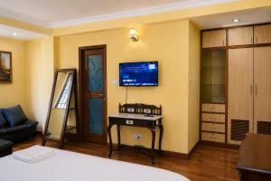 a bedroom with a bed and a tv on the wall at Du Nepal Inn in Kathmandu
